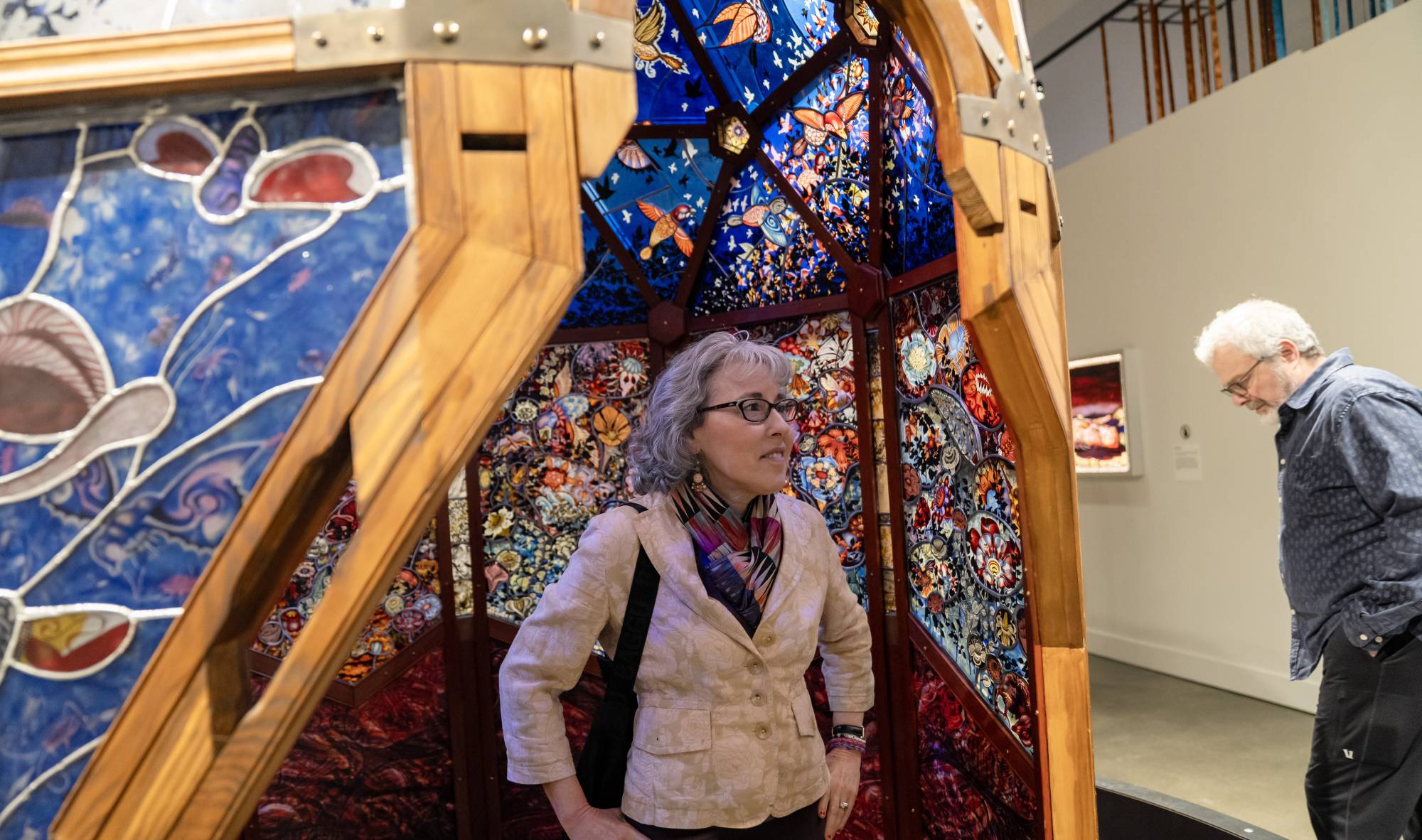 Person standing in front of Judith Schaechter's 8-foot stained glass done