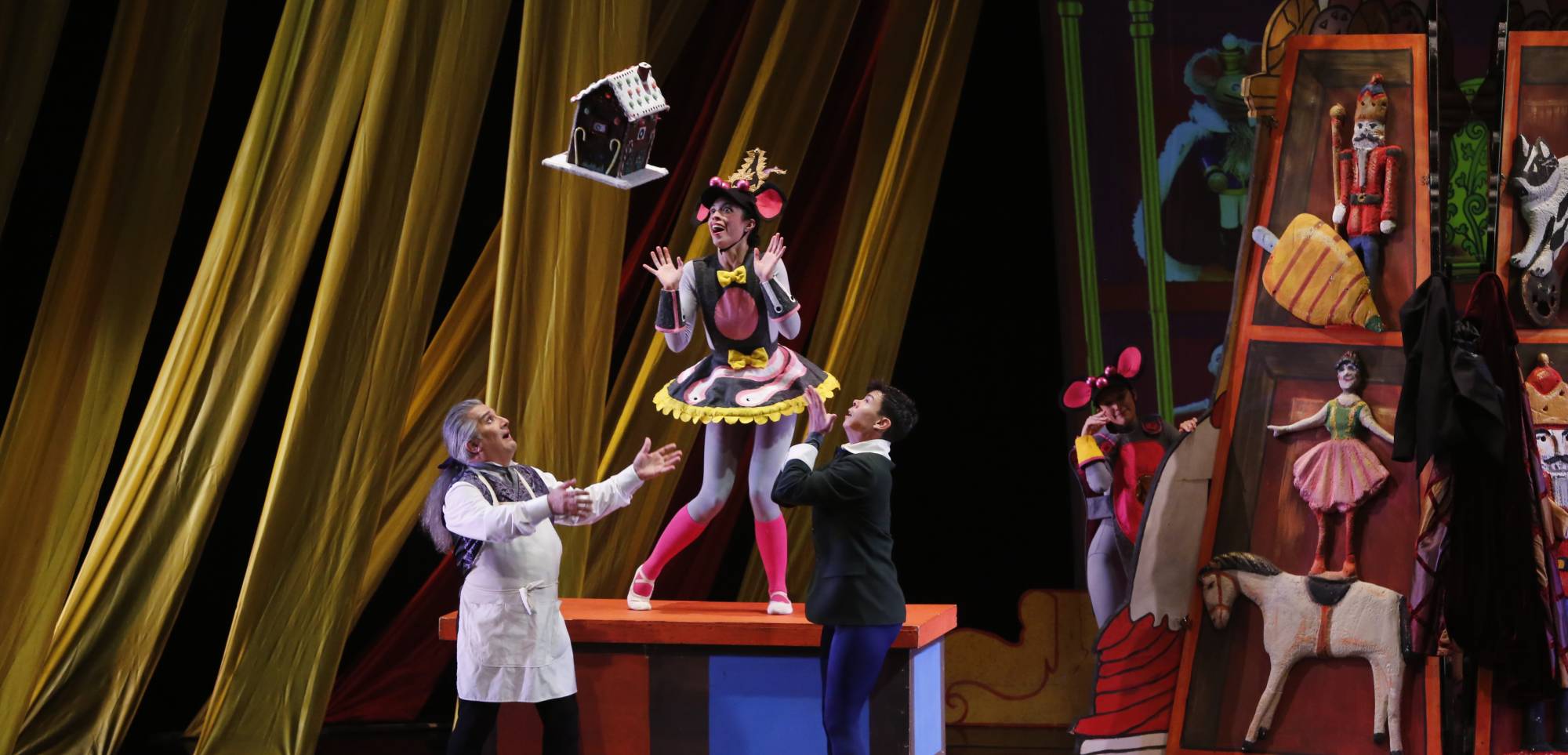 A photograph of the Nutrcracker Sweets show with four actors up on a Christmas-themed stage
