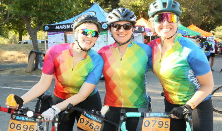 3 people wearing rainbow biking attire