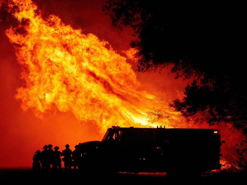 Butte county firefighters watch as flames tower over their truck during the Bear fire in Oroville, California on September 9, 2020.