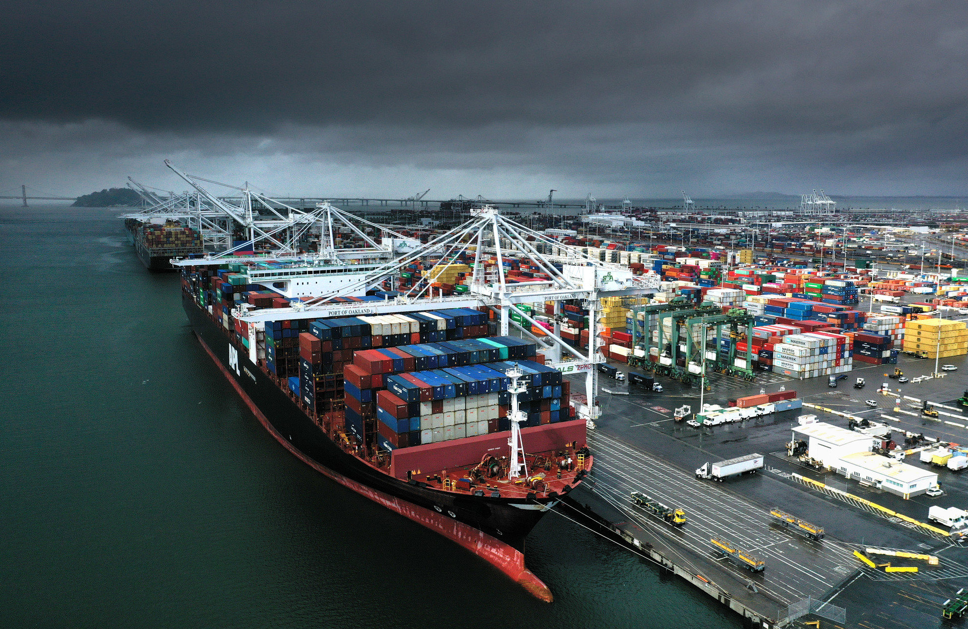 An aerial view of a very large container ship docked at a port.