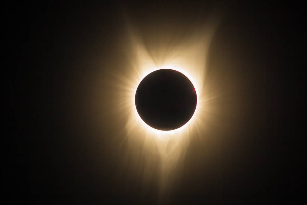 A view of a total solar eclipse when the moon fully blocks the sun to create a dark sky.