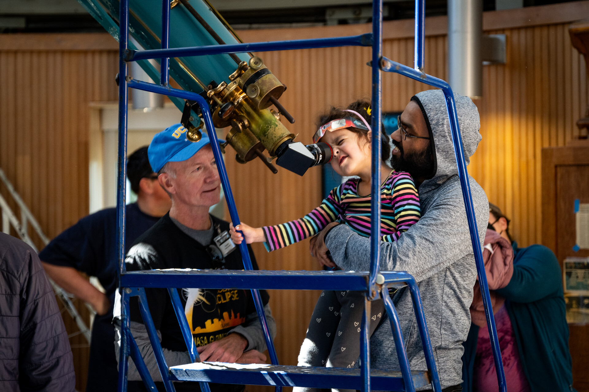 A child looks into a telescope.