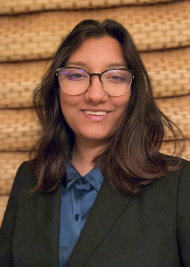 A headshot photo of Vanya Agrawal. The student wears glasse and a blue collared shirt under a black blazer.