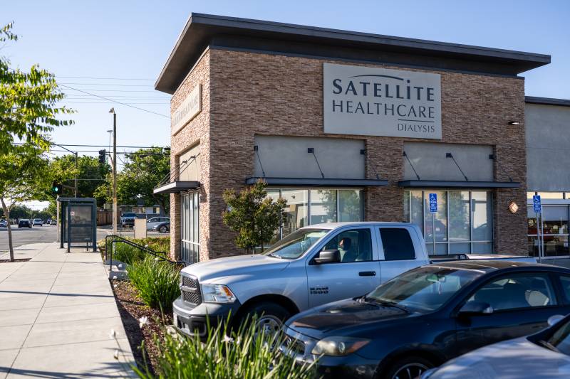 An image of a building with cars parked in front. The sign on the building reads "Satellite Healthcare Dialysis."