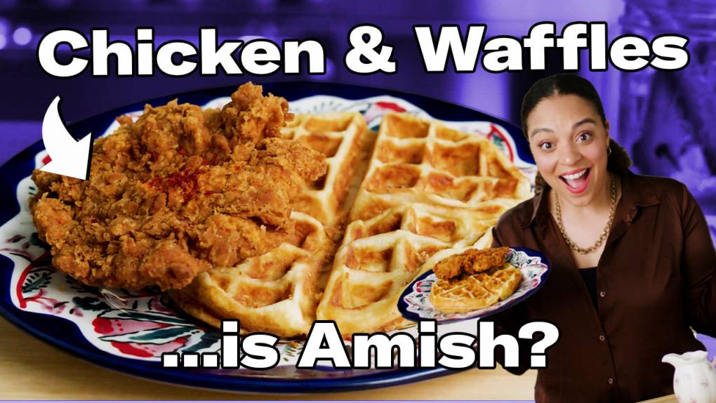 A plate with a piece of fried chicken sitting on top of a waffle next to the show's host, Cecilia Phillips