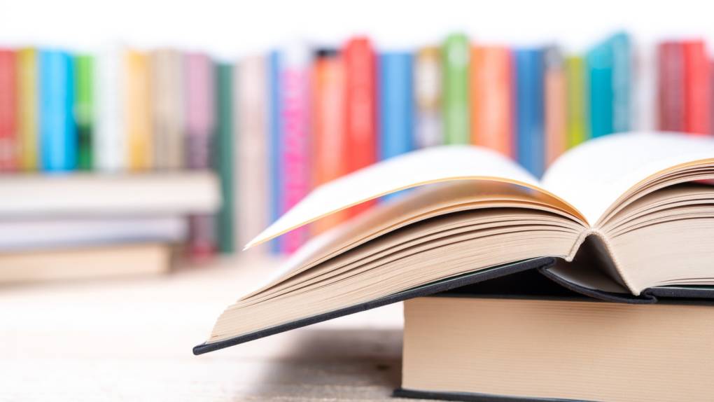 open book with library bookshelf in background