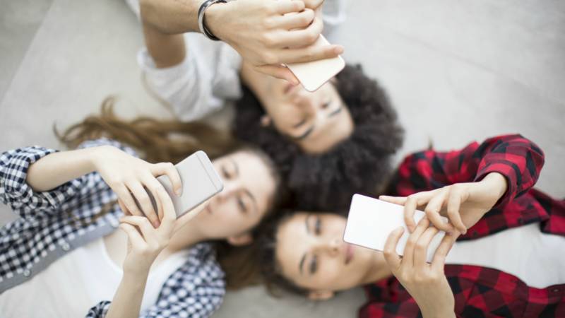 Teens looking at their phone.