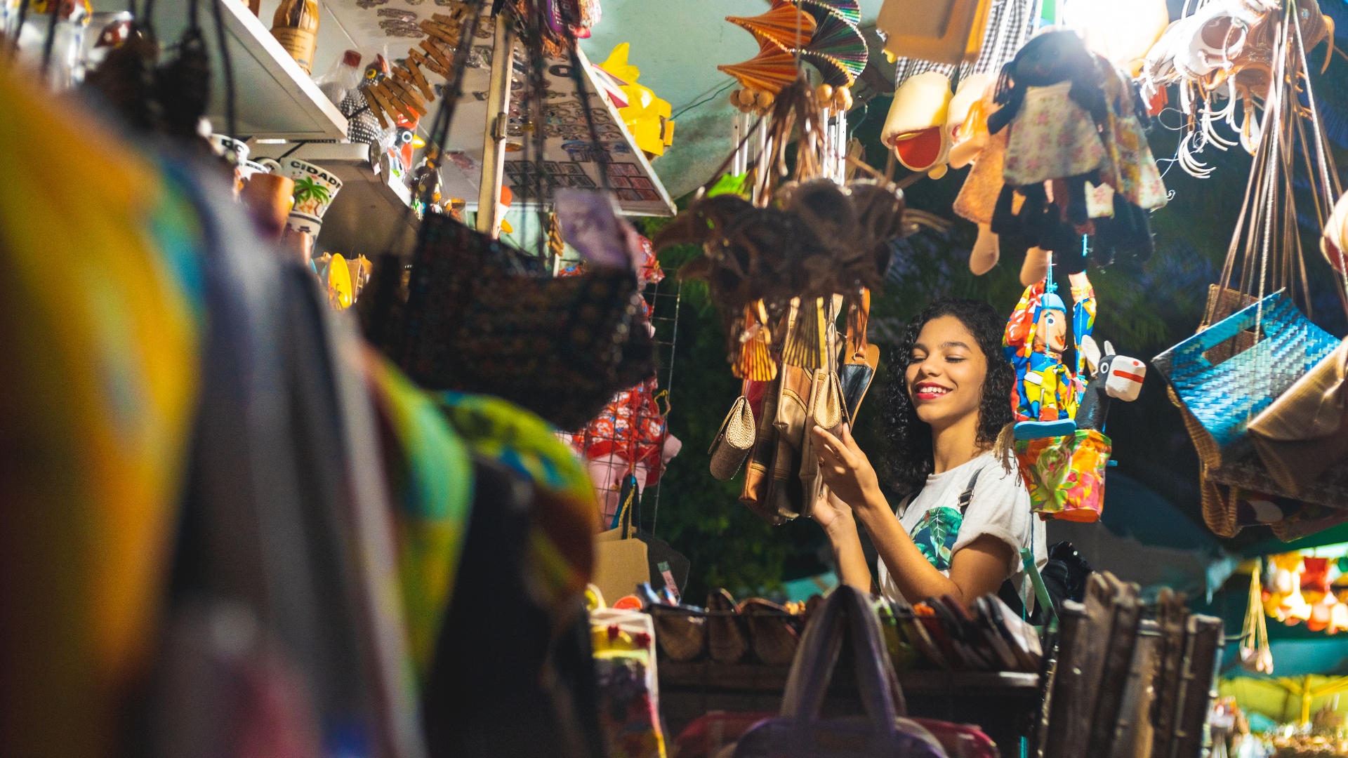 woman in shop surrounded by bags hanging from racks
