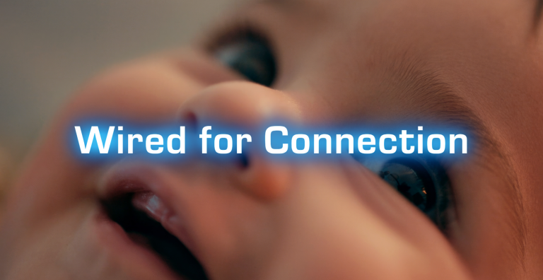 Close-up photo of a smiling baby's face with the film title, "Wired for Connection" written across.