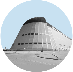 Hangar One sits in Moffett Field in Santa Clara County. The image is in black and white and contained in a light blue circle.