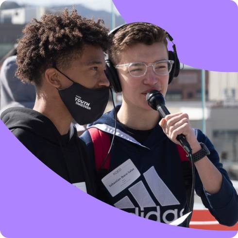 Two students, one with a microphone and headphones